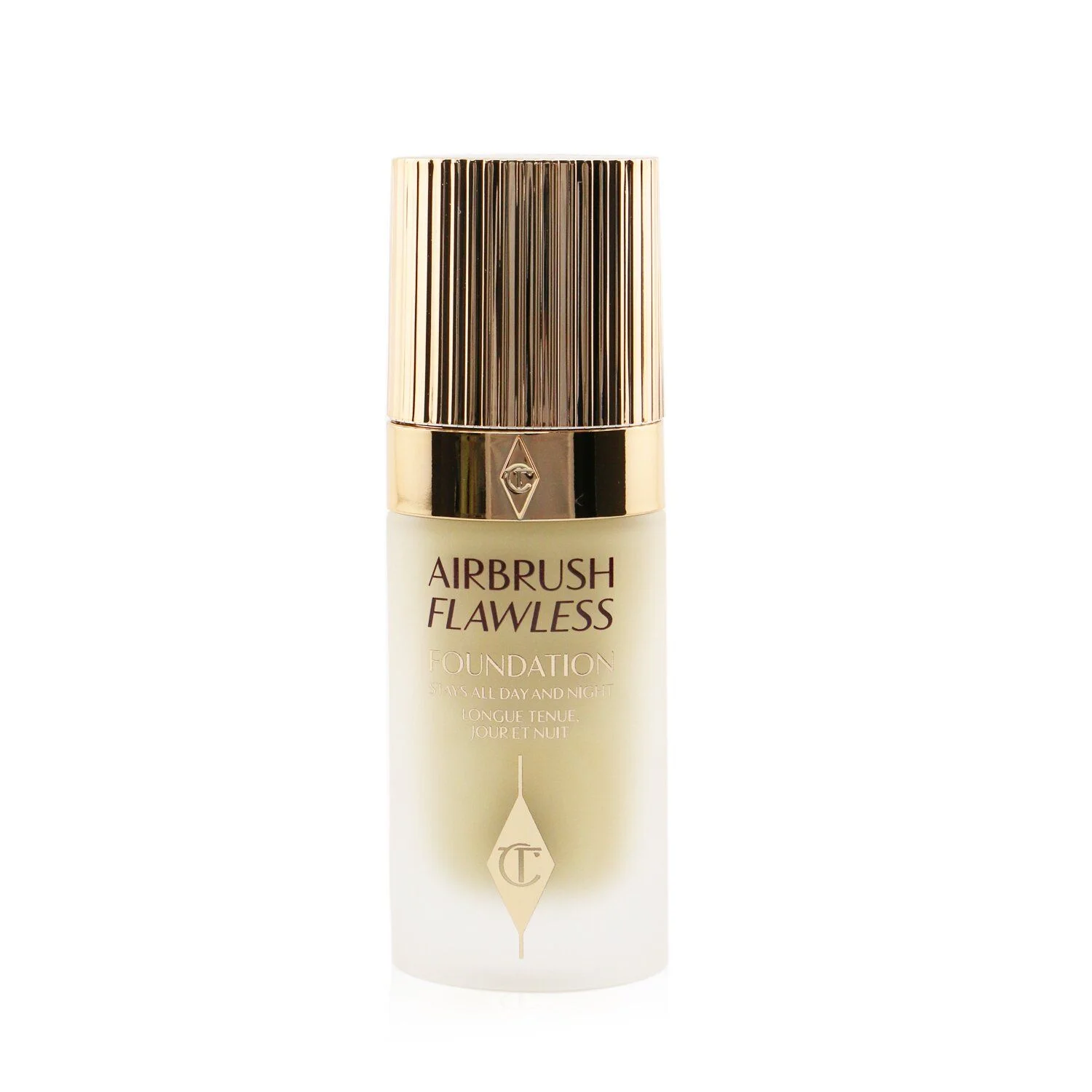 A front view of a Charlotte Tilbury Airbrush Flawless Foundation bottle is centered against a white background. The bottle has a gold ridged cap and a clear glass body with a frosted finish. The text 'AIRBRUSH FLAWLESS FOUNDATION' is printed on the front of the bottle in black, along with smaller text that reads 'STAYS ALL DAY AND NIGHT' and 'LONGUE TENUE JOUR ET NUIT' in a lighter shade of gold. A diamond-shaped logo with the letter 'C' inside it is also embossed in gold on the bottle.