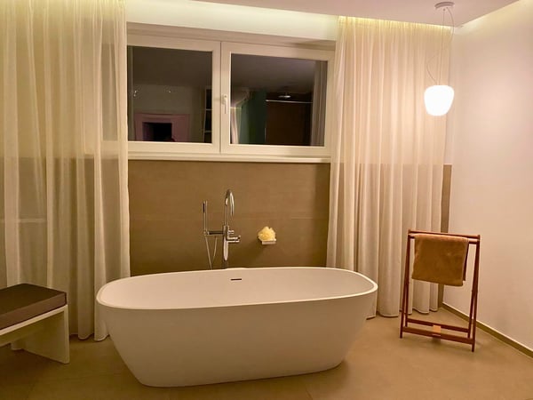 In diesem zeitlos eleganten Badezimmer dominieren neutrale Farben und eine einladende Atmosphäre. Die großen Natursteinfliesen in einem schönen Beige-Grau Ton verleihen dem Raum eine edle Note.