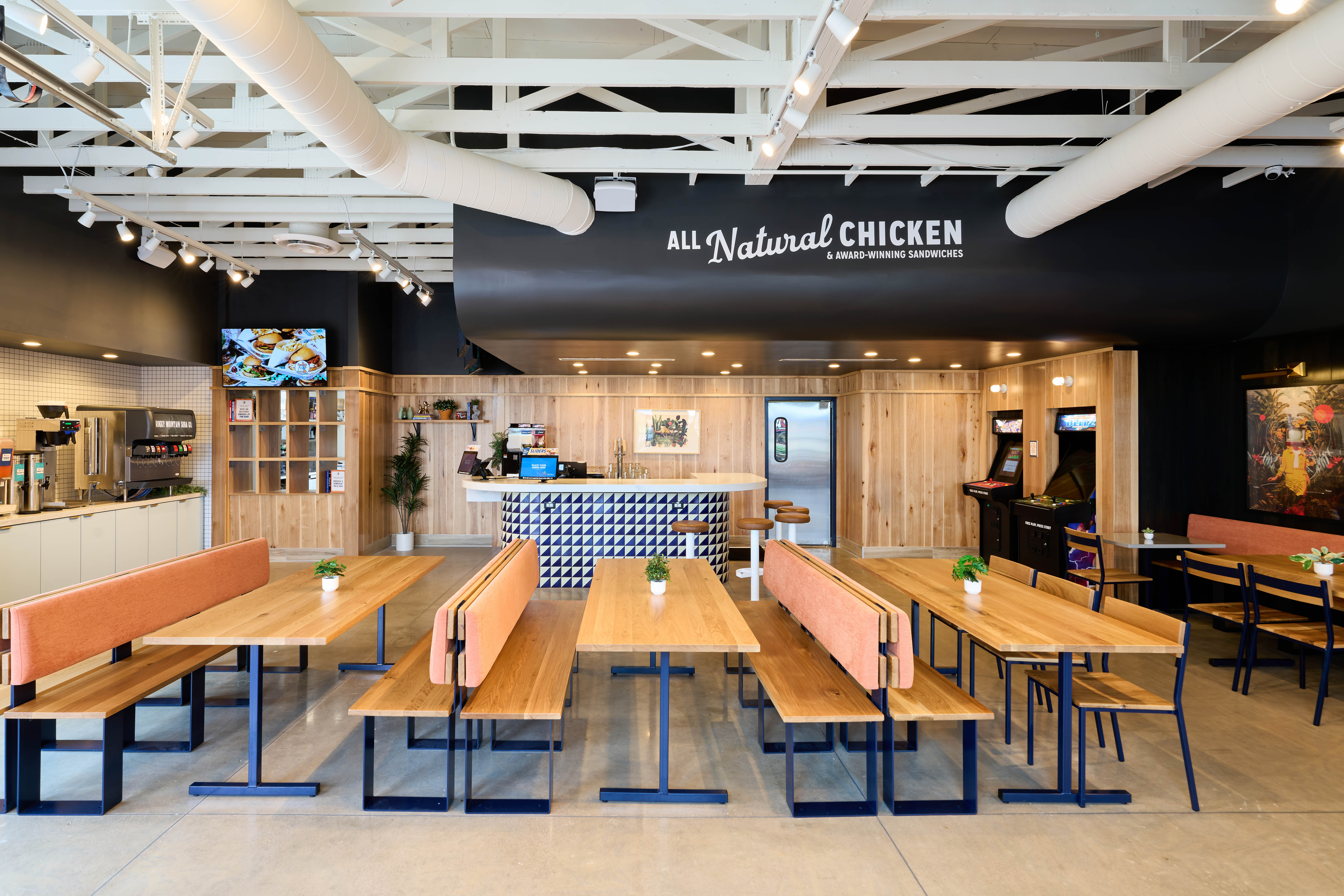 Interior view of dining room, highlighting the booths, ordering system, and pick up bays.