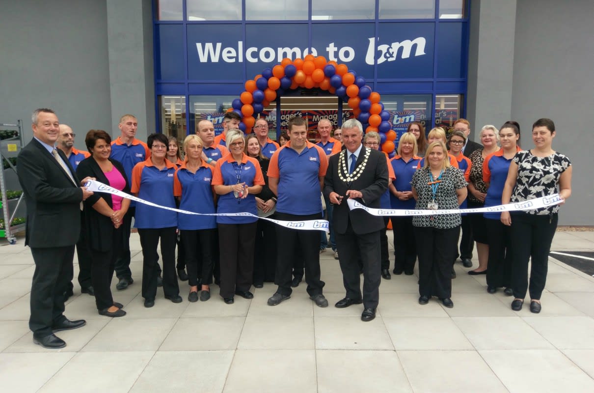 Mayor of Belper Gary Spendlove, supported by Sue Ryder charity, cuts the ribbon at B&M Belper store's re-opening, following a 9 month redevelopment.