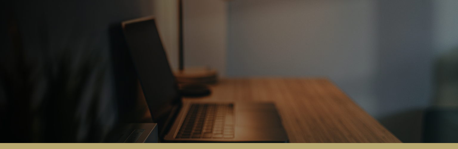 Blurred photo of an open laptop on a desk.