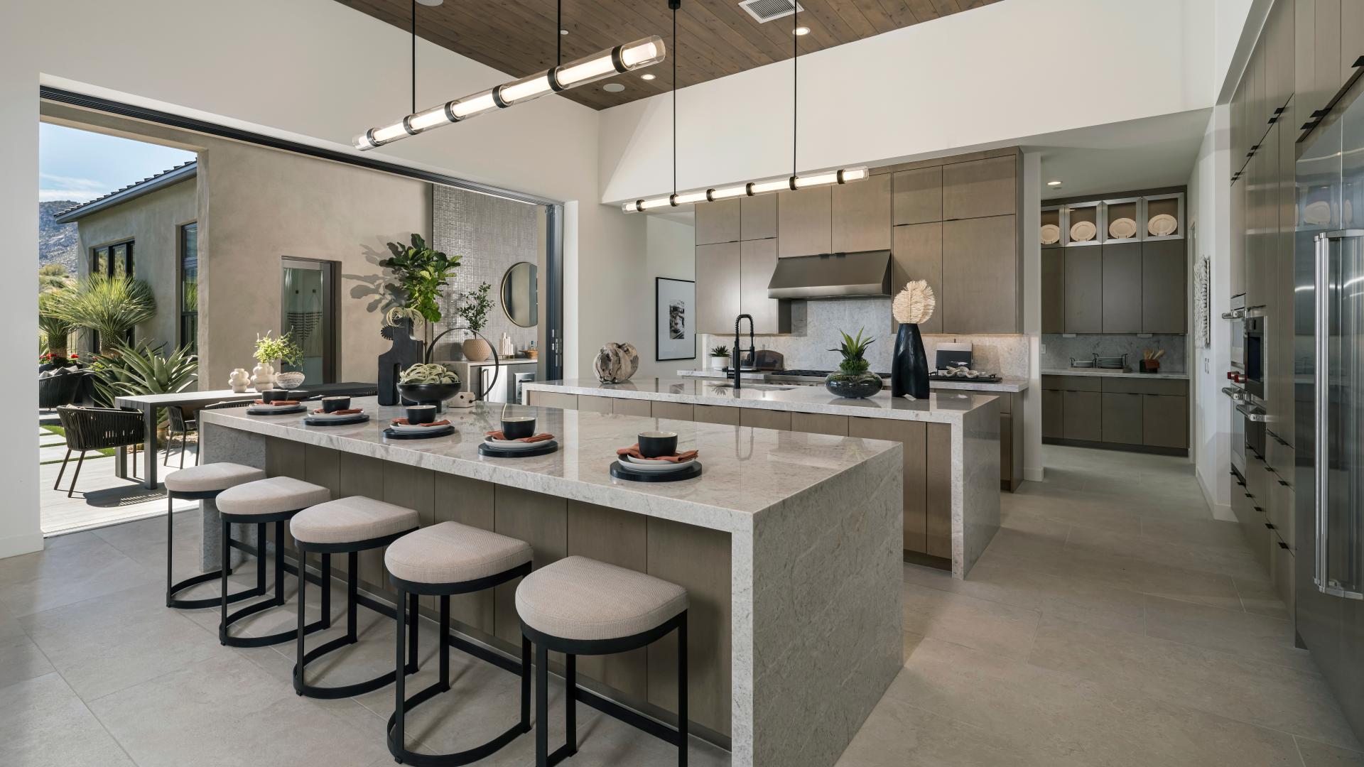 Gourmet kitchens with dual waterfall islands and stainless steel Wolf and SubZero appliances