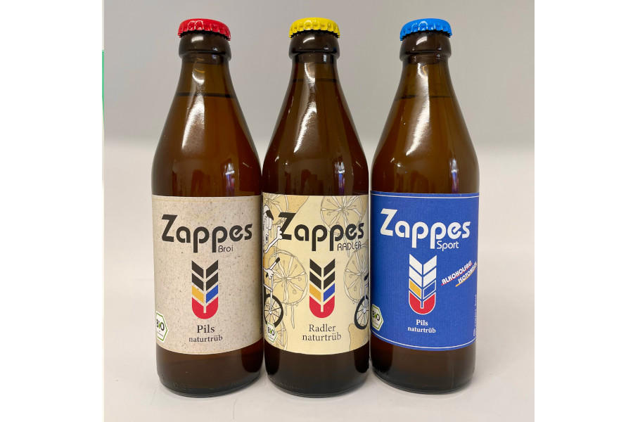 Zappes
Zappes denkt Bier neu: Das Pils ist in Bio-Qualität und naturtrüb hergestellt. Gleichzeitig wurde es perfekt auf den Gaumen des Rheinländers abgestimmt und überzeugt durch einen milden, aber süffigen Geschmack. Alle Zutaten, die von der Brauerei verwendet werden, sind vegan und aus biologischem Anbau.