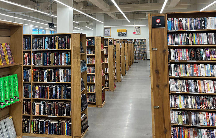 DVD section and shelves of books at HPB Westlane Avenue, a new and used bookstore that buys and sells items in Columbus, Ohio.