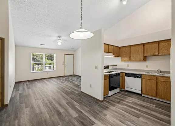 A kitchen with wooden cabinets and a grey floor 