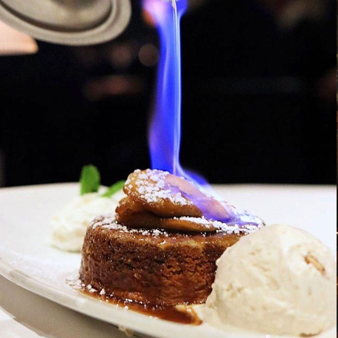 Our signature Bananas Foster is flambeÌed tableside and served with butter pecan ice cream.