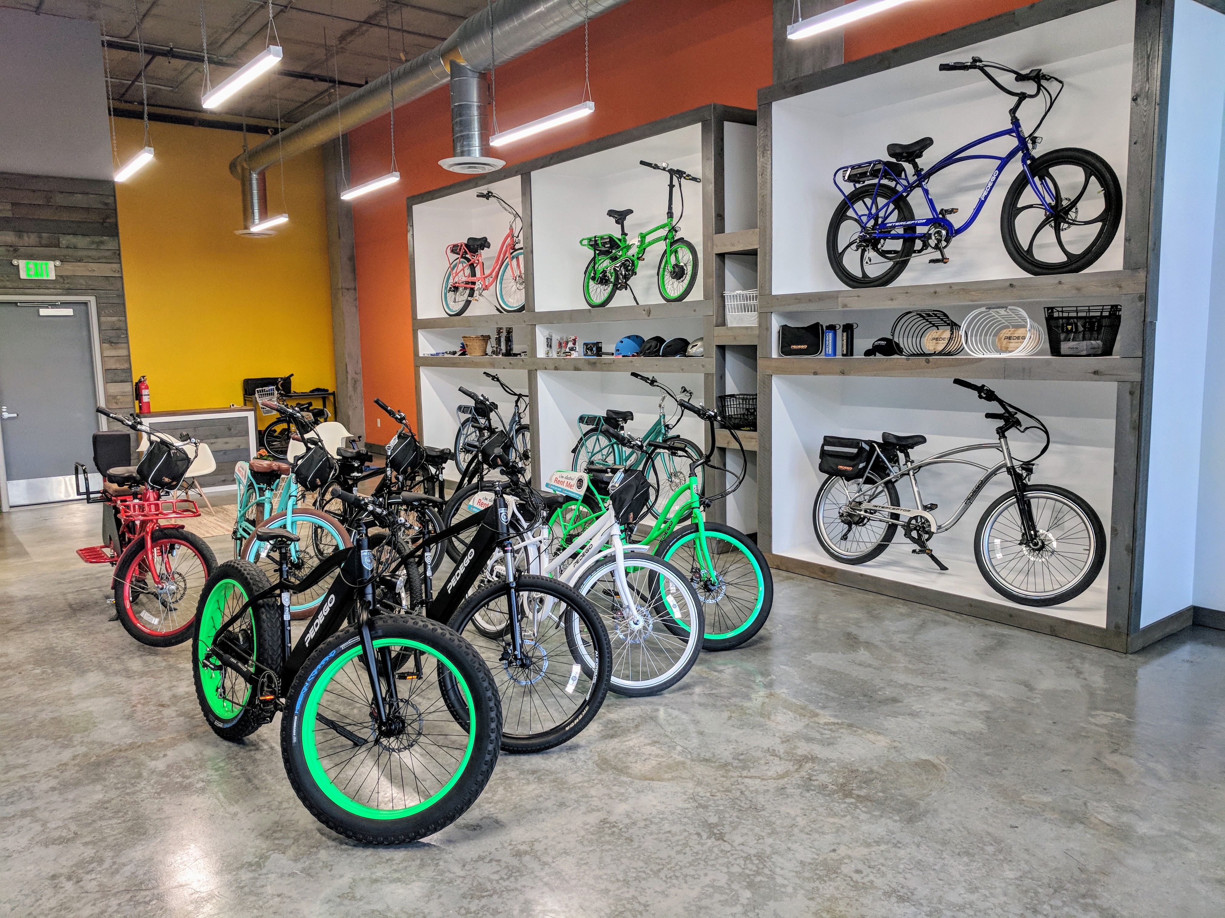 Inside Pedego San Diego retail store with several bikes and accessories on display.