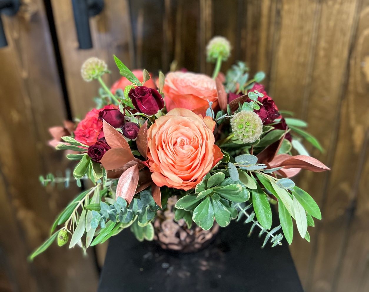 Rose arrangement featuring kahala roses, rubicon spray roses, scabiosa pods mix of greenery including eucalyptus, pittosporum, ruscus and olive branches.