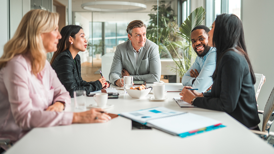 Five people at a conference table