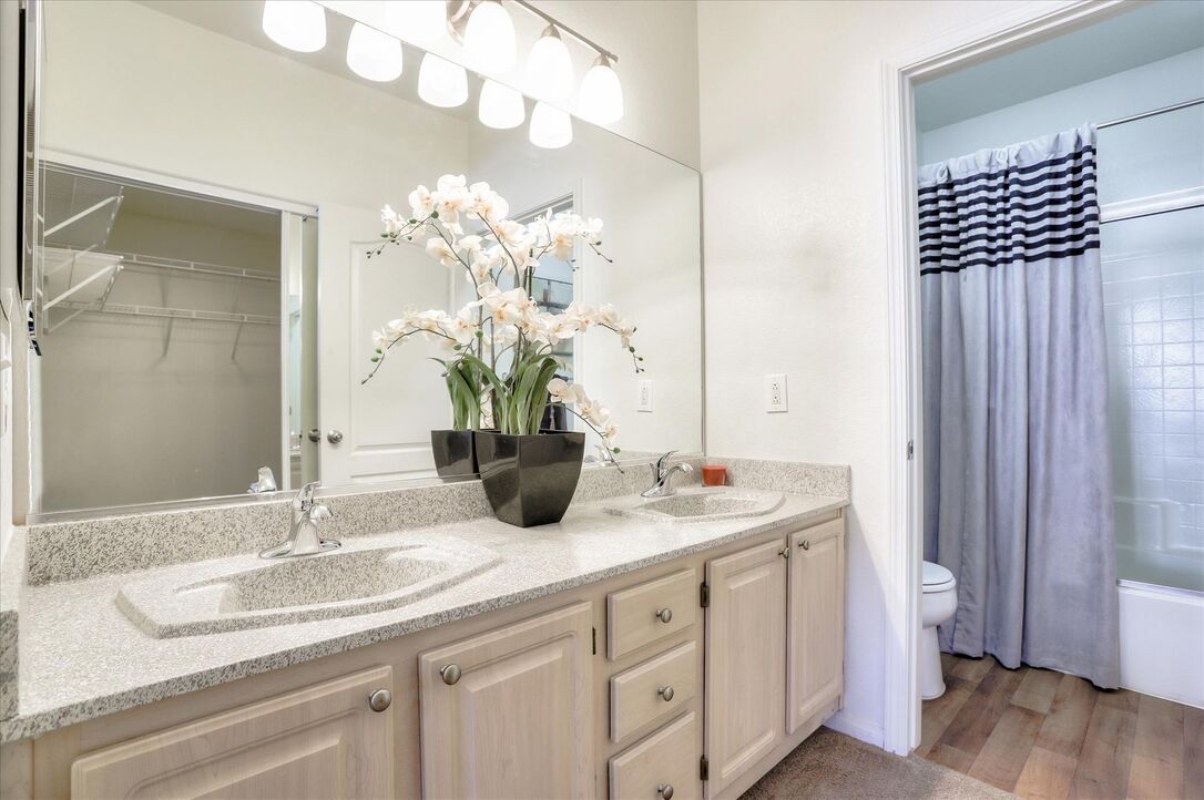 Image of a bathroom featuring a vanity mirror with light, a single sink, and a tub and shower combo.