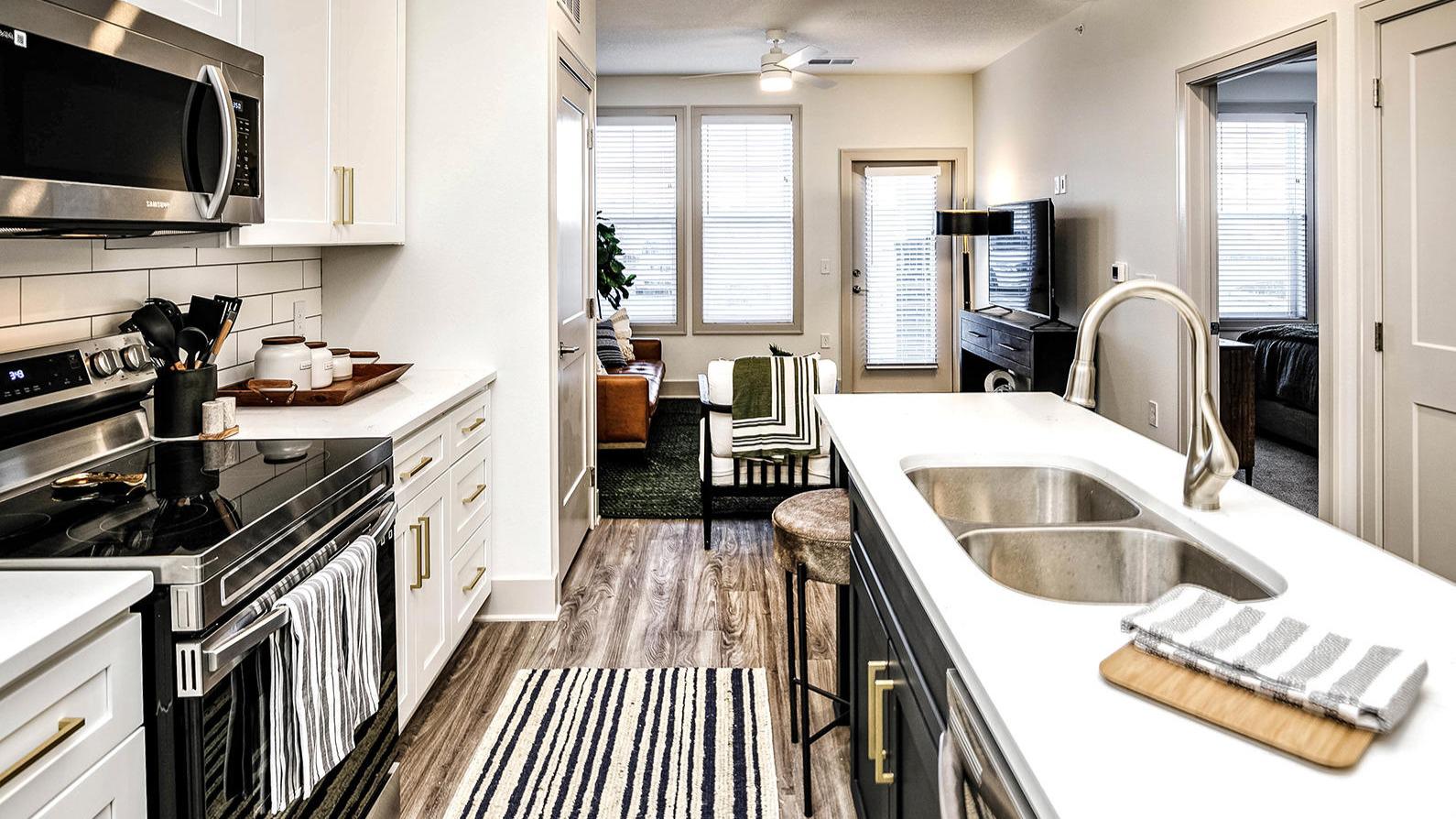 Studio, one, and two-bedroom apartment homes with stainless steel appliances, quarts countertops, designer cabinetry, large kitchens, luxury vinyl plank flooring, high vaulted ceilings, high-end lighting, in-unit washer and dryer, and energy efficient windows at Fireside at Waukee in Waukee, IA