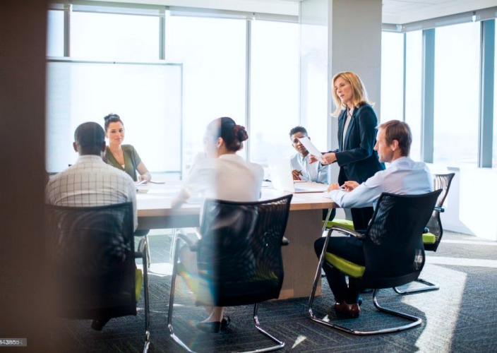 A team of six having a meeting in a boardroom.