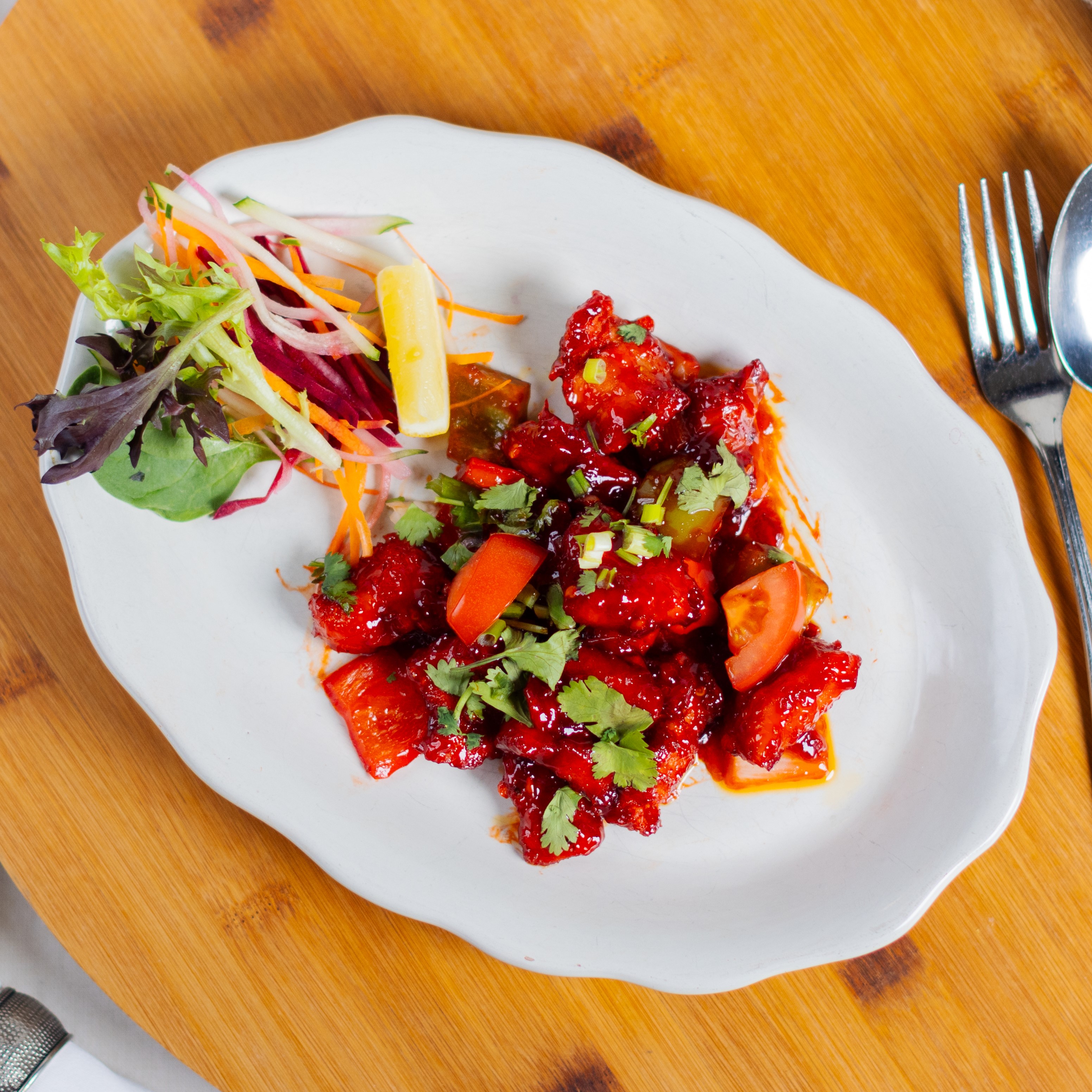 Crispy, wok-tossed chicken cooked with garlic, ginger, green chilies, onions, and bell peppers in a  