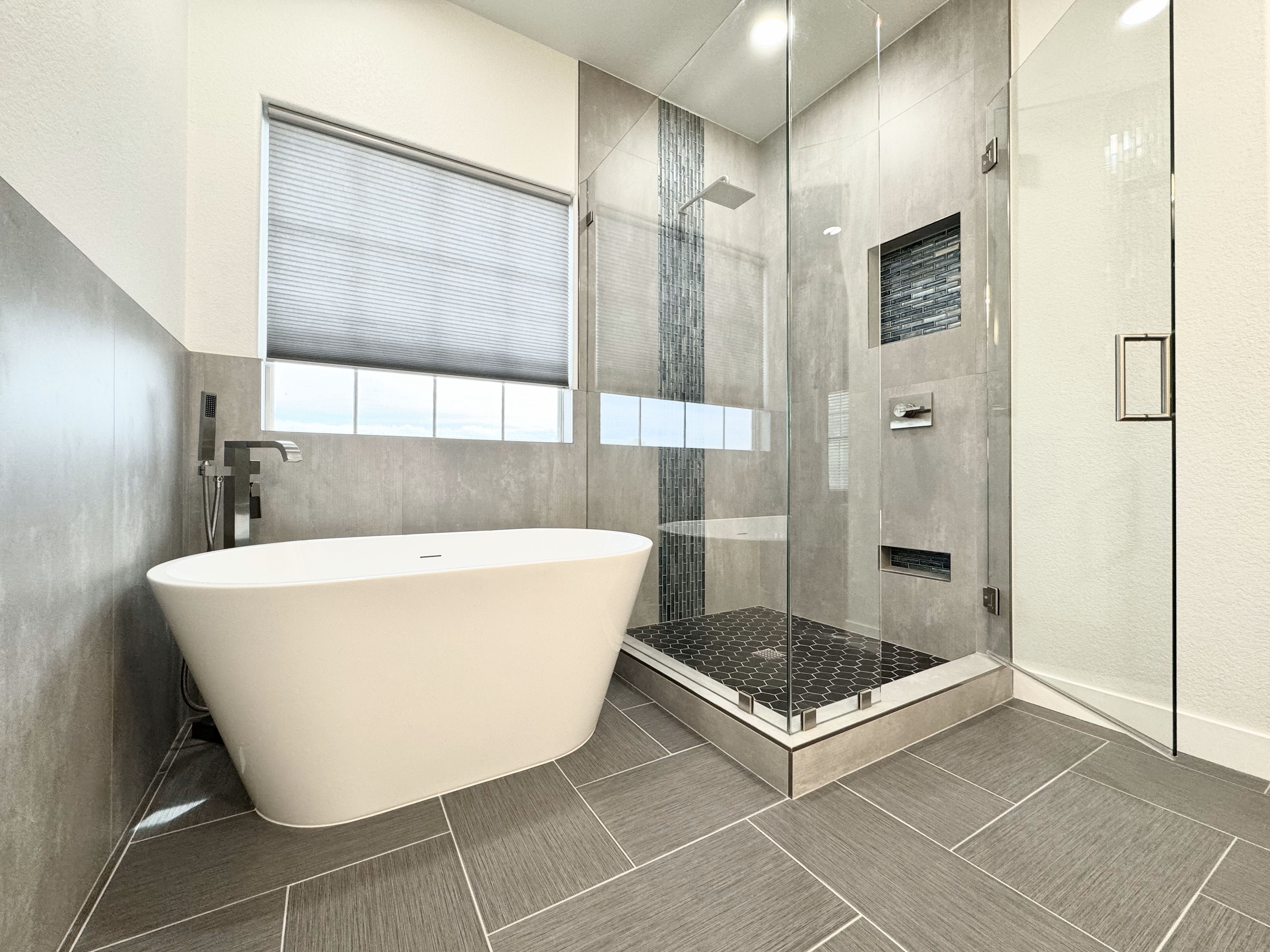 Here's one of our finished bathroom remodeling projects at Ledezma Remodeling—a modern bathroom featuring a sleek freestanding tub and a custom shower design. Visit our website to learn more about our bathroom remodeling services.