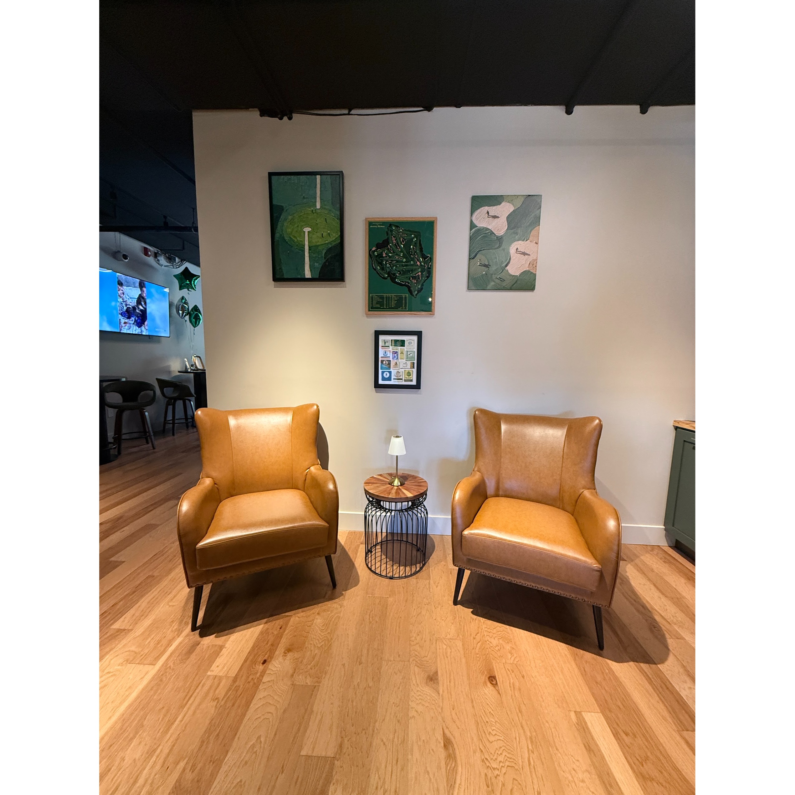A cozy club-style lounge at The Approach Shot, offering a comfortable space to relax, socialize, and enjoy the indoor golf experience