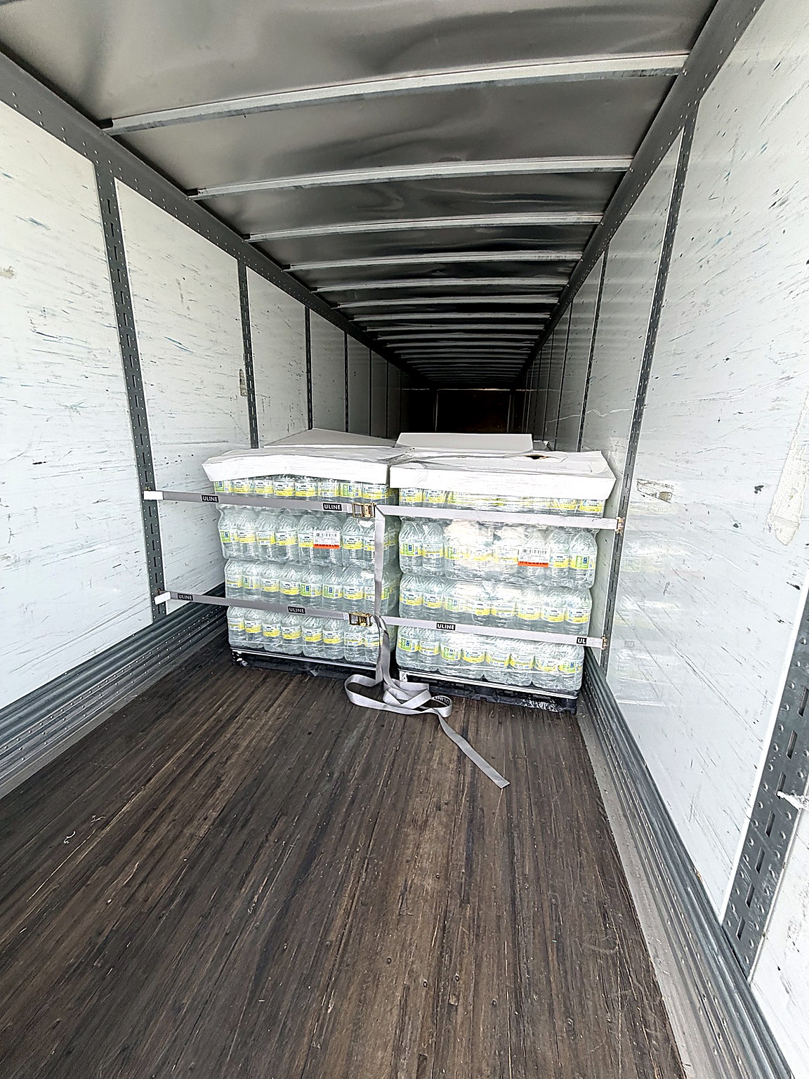 AeroLuxe Ground Inc. dry van freight image showing palletized bottled water secured inside a commerc 