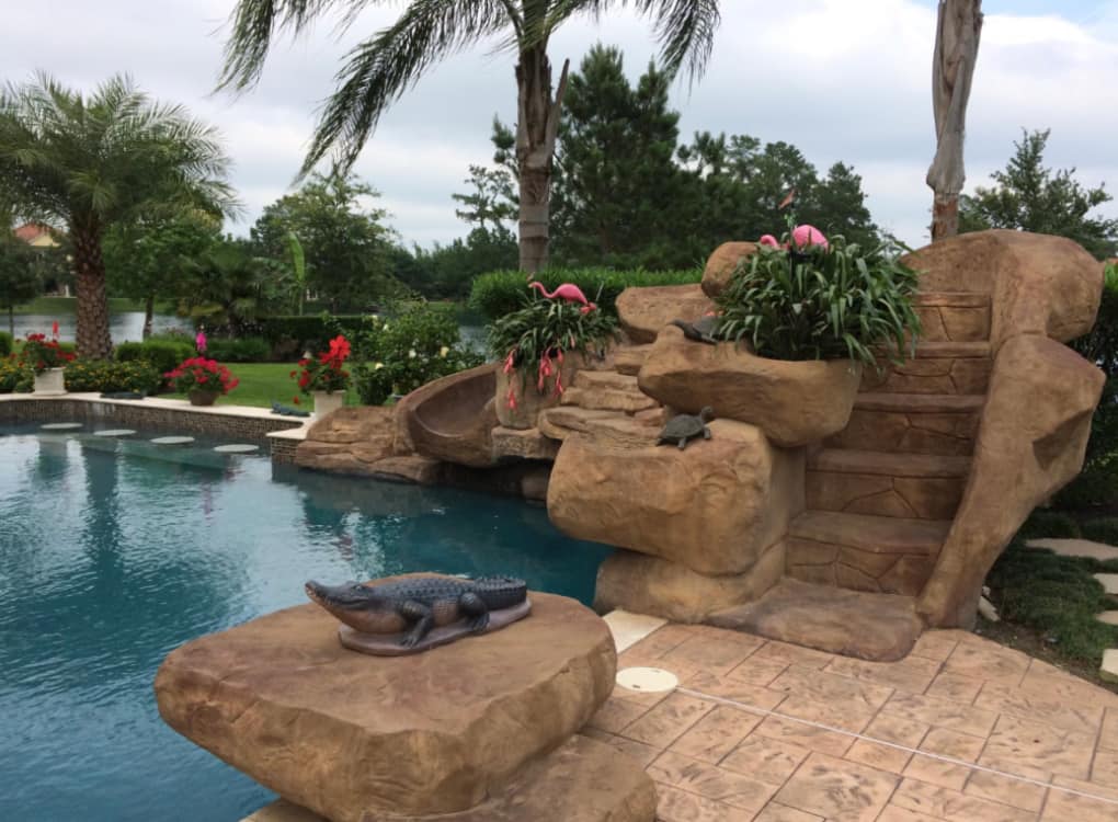 Stone waterfall with slide and landscaped plants
