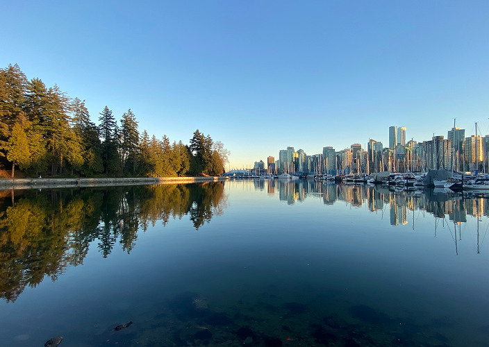Water in the foreground with the Vancouver skyline in the background.