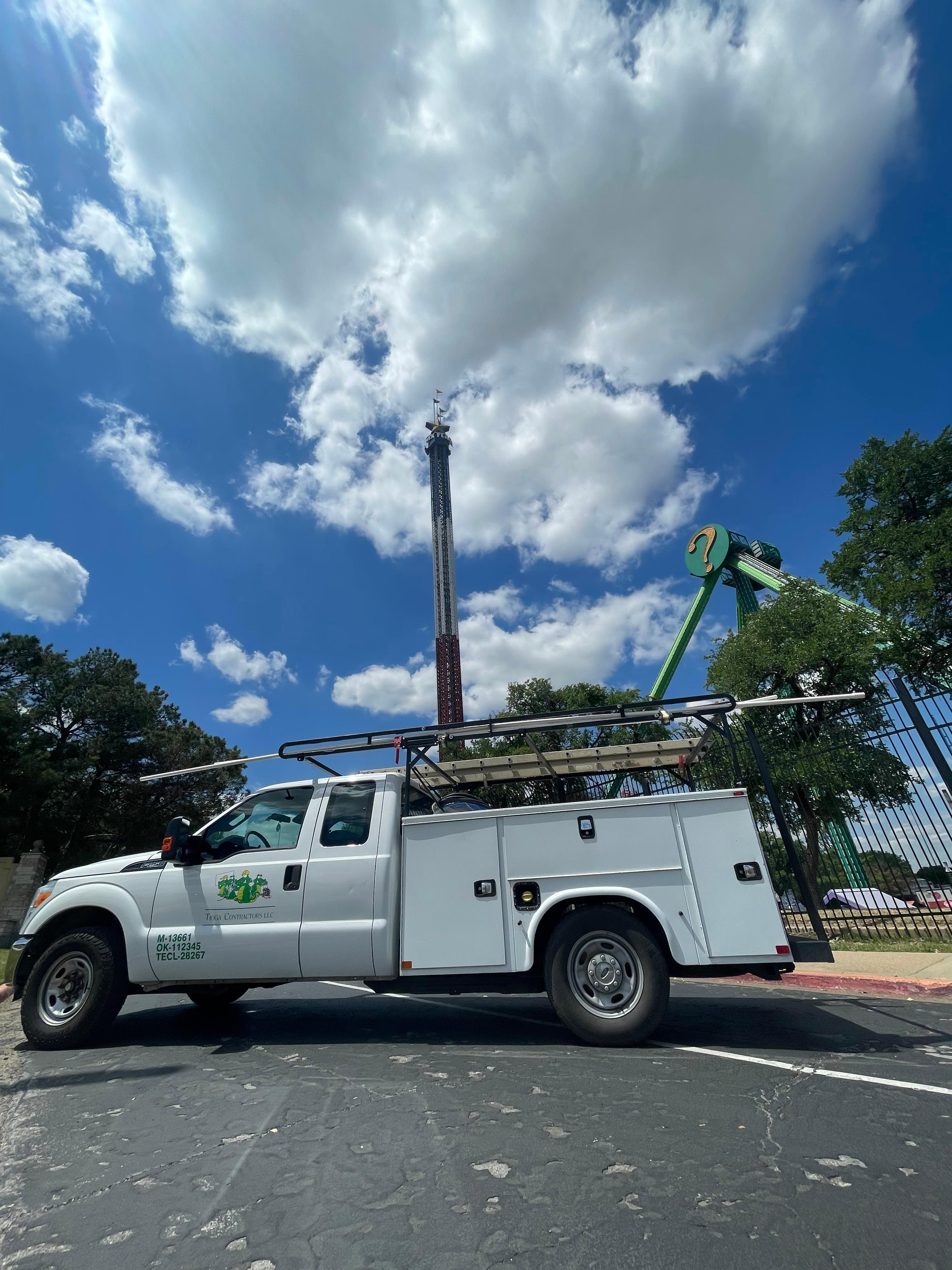 A Tioga service truck in front of Six Flags rides in Arlington Texas.