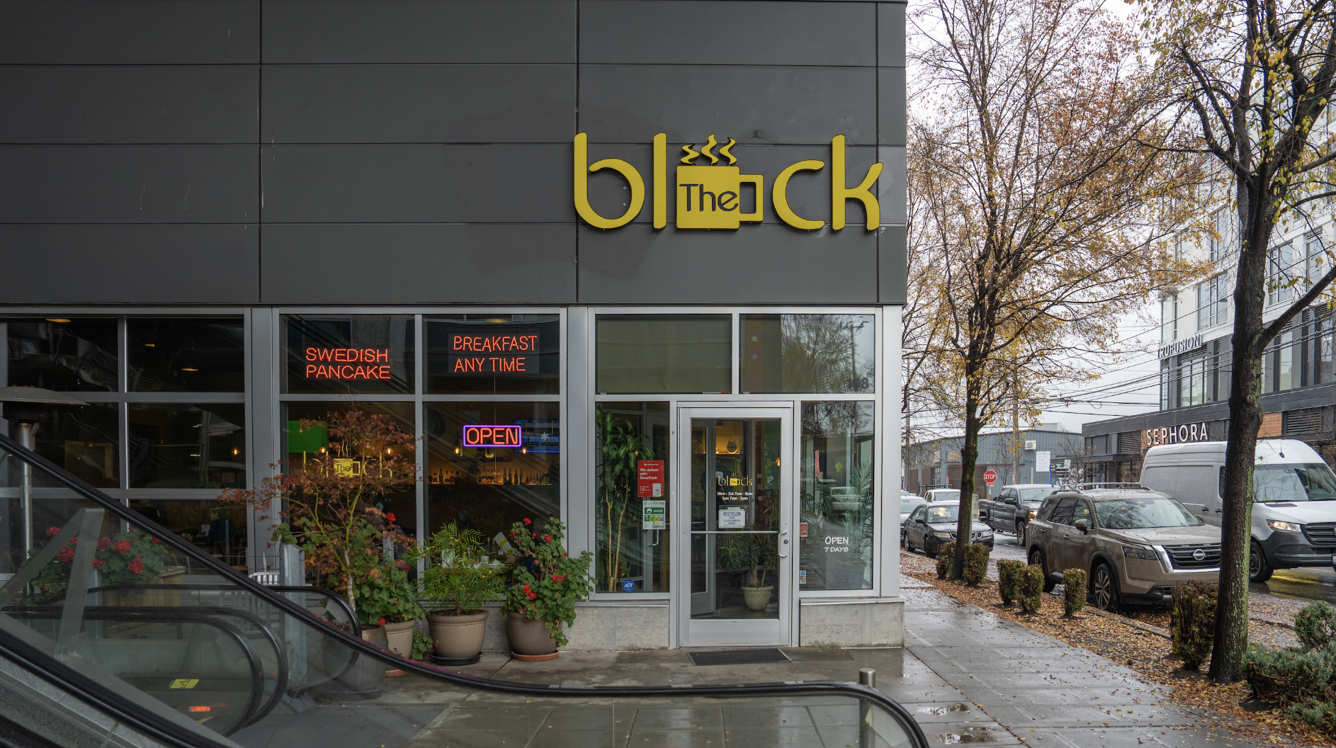 The outside of the restaurant, a gray building with a yellow logo for "The Block"