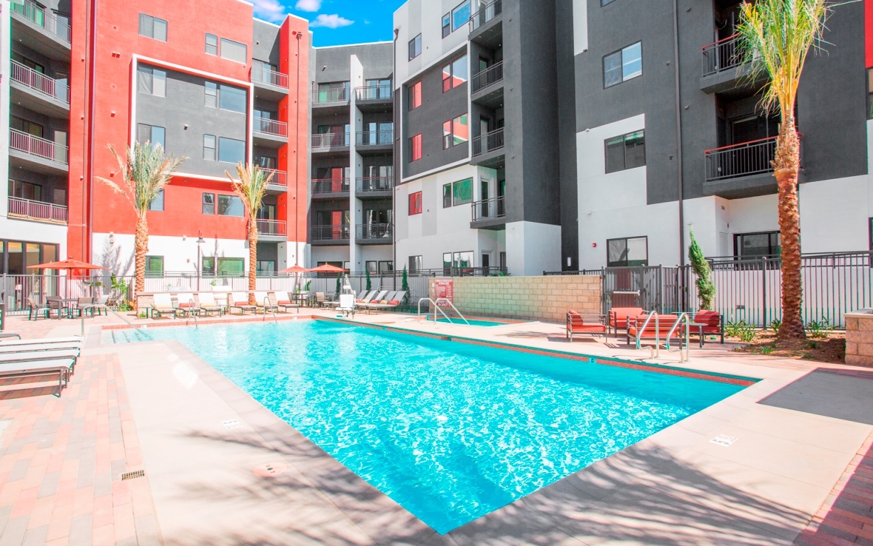 A swimming pool in front of apartment buildings.