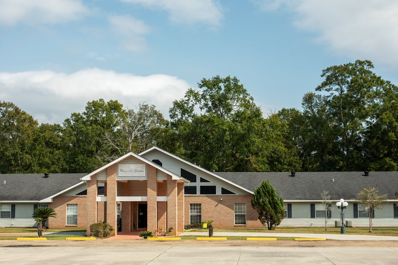 Magnolia Garden Inn &amp; Suites Logo