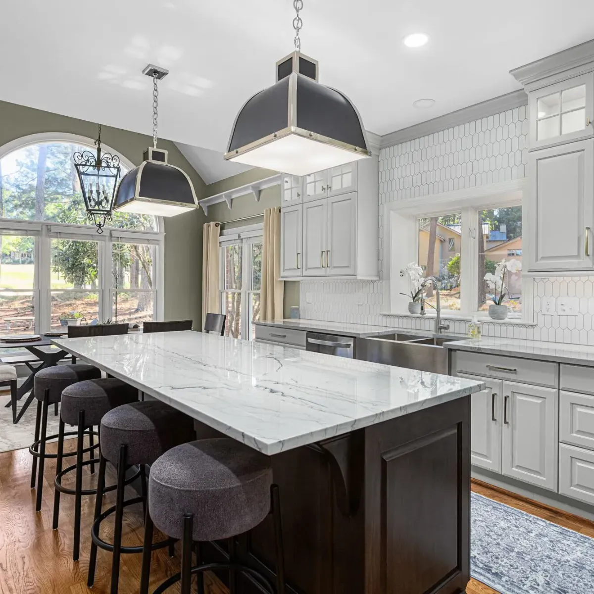 Custom kitchen remodel near Badin Lake, North Carolina showcasing an oversized marble island, modern pendant lighting, and custom cabinetry. This project reflects high-quality residential construction and luxury home remodeling services.