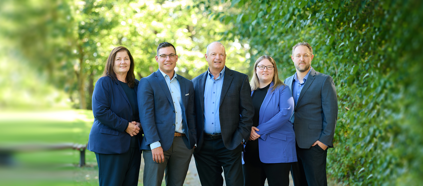 The Balfe Martin Private Wealth team standing together surrounded by greenery.
