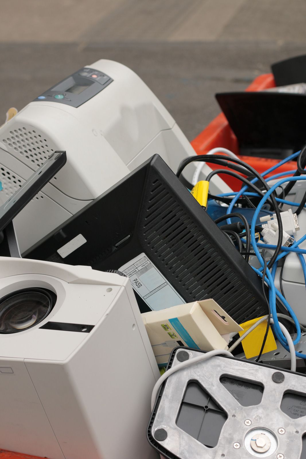 Collection of discarded electronics including monitors, cables, and devices, highlighting e-waste disposal, recycling services, and responsible removal of outdated equipment.