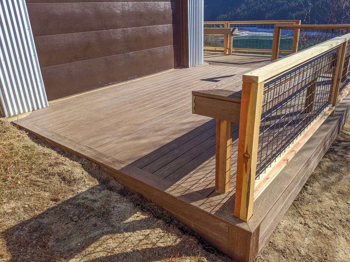 This custom DeckPro LLC project perfectly blends rustic character with modern durability. Featuring rich brown composite decking for low maintenance, the design is highlighted by a unique natural wood and industrial wire mesh railing. A custom built-in bench provides integrated seating without sacrificing space.