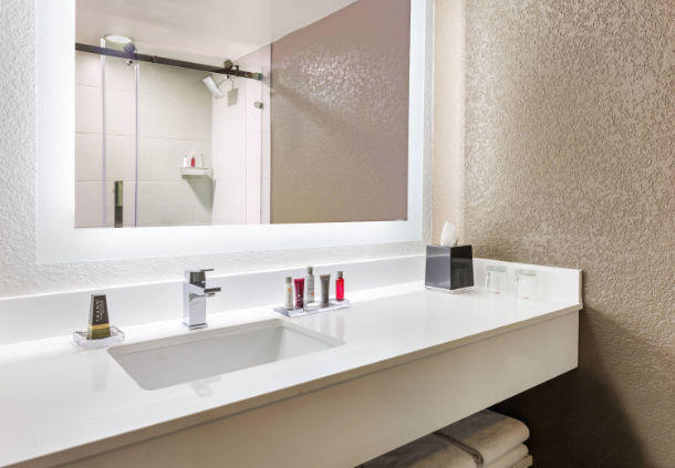 Our spacious guest bathrooms showcase sleek accents and a back-lit vanity mirror.