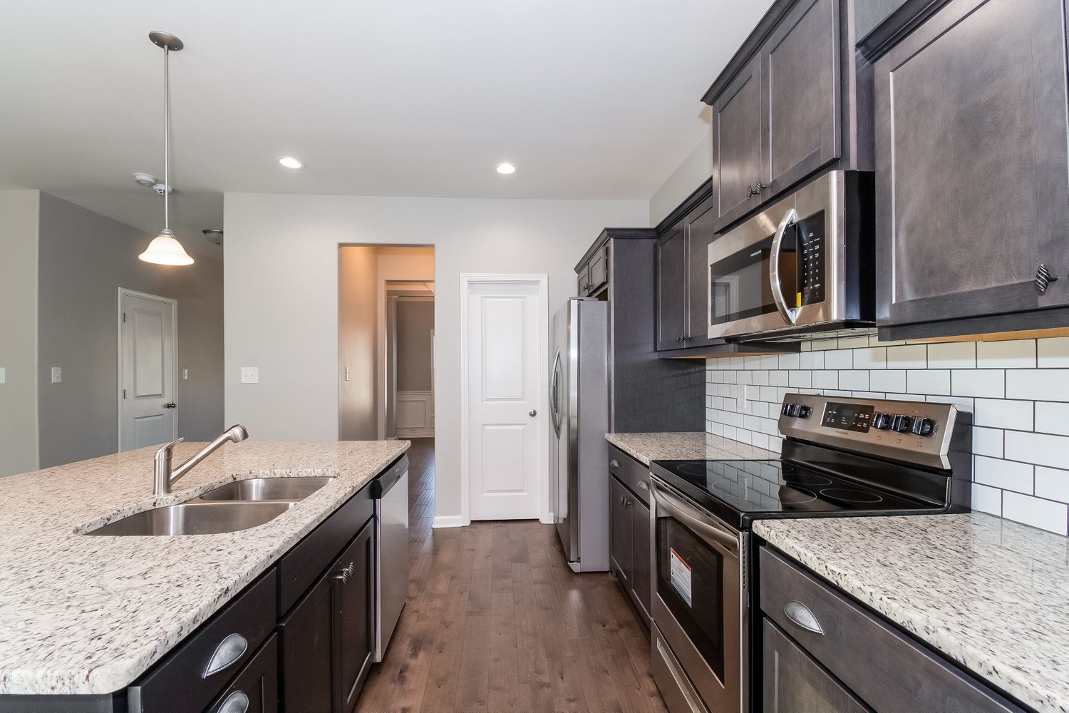 Modern kitchen with stainless steel appliances and an island at Invitation Homes Atlanta.