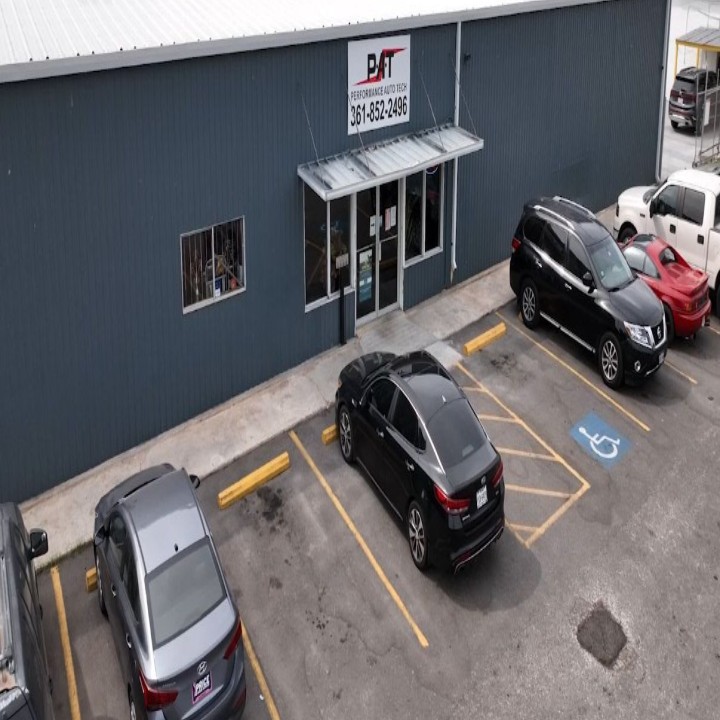 Exterior view of a local auto repair shop with several cars parked in front, showcasing its welcomin 