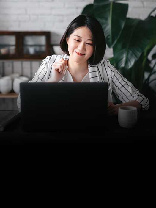 A woman working on the computer in her office.