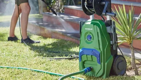 A person cleaning a patio with a pressure washer