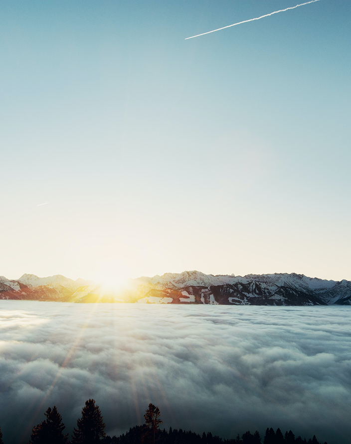 Snow-capped mountain peaks viewed from above the cloud line.