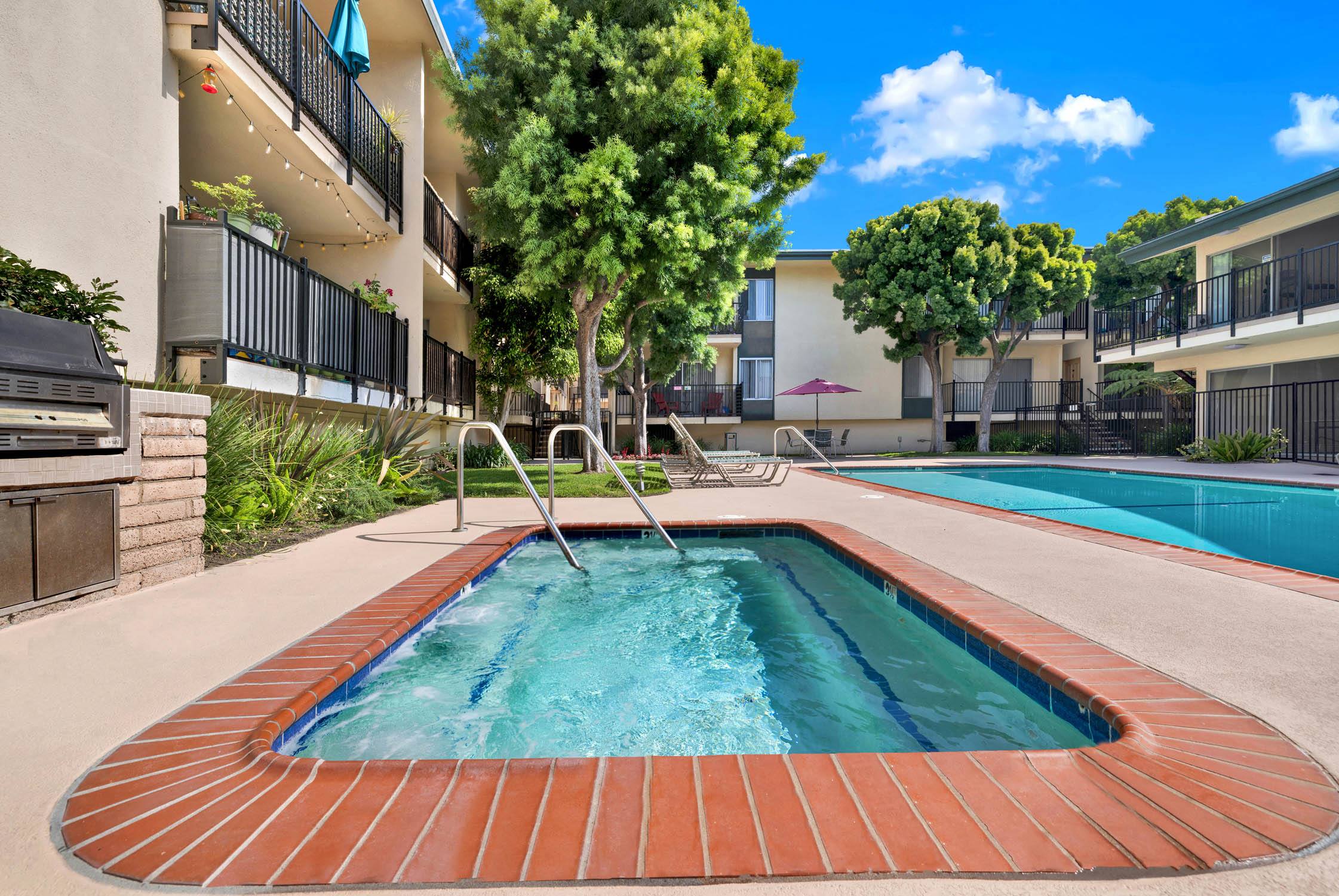 a resort style pool is next to an apartment building