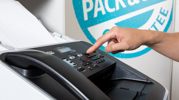 Close up photo of employee faxing documents