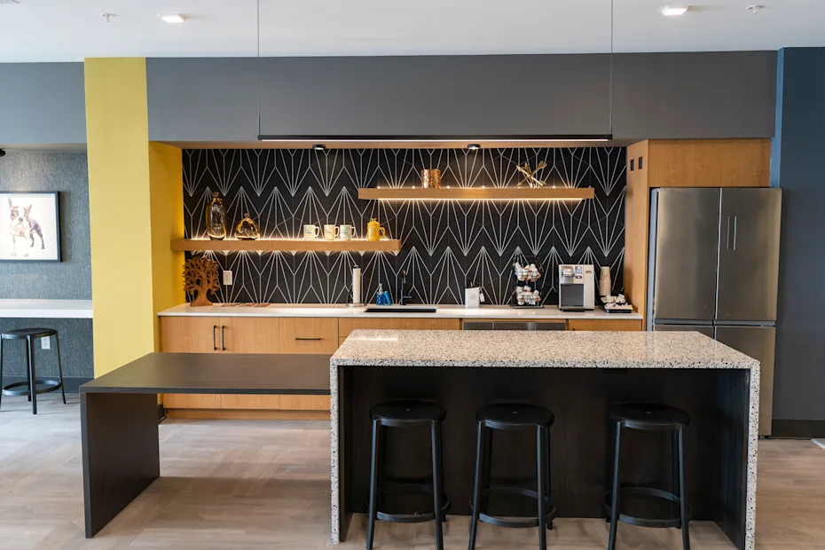 A modern kitchen with a bar area and stools 