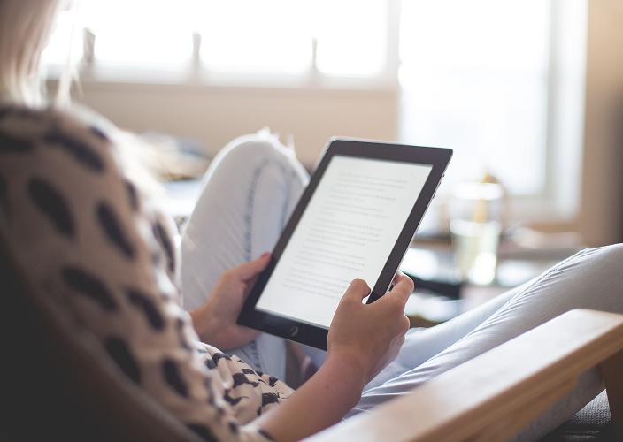 A woman reviewing an electronic document on her tablet.