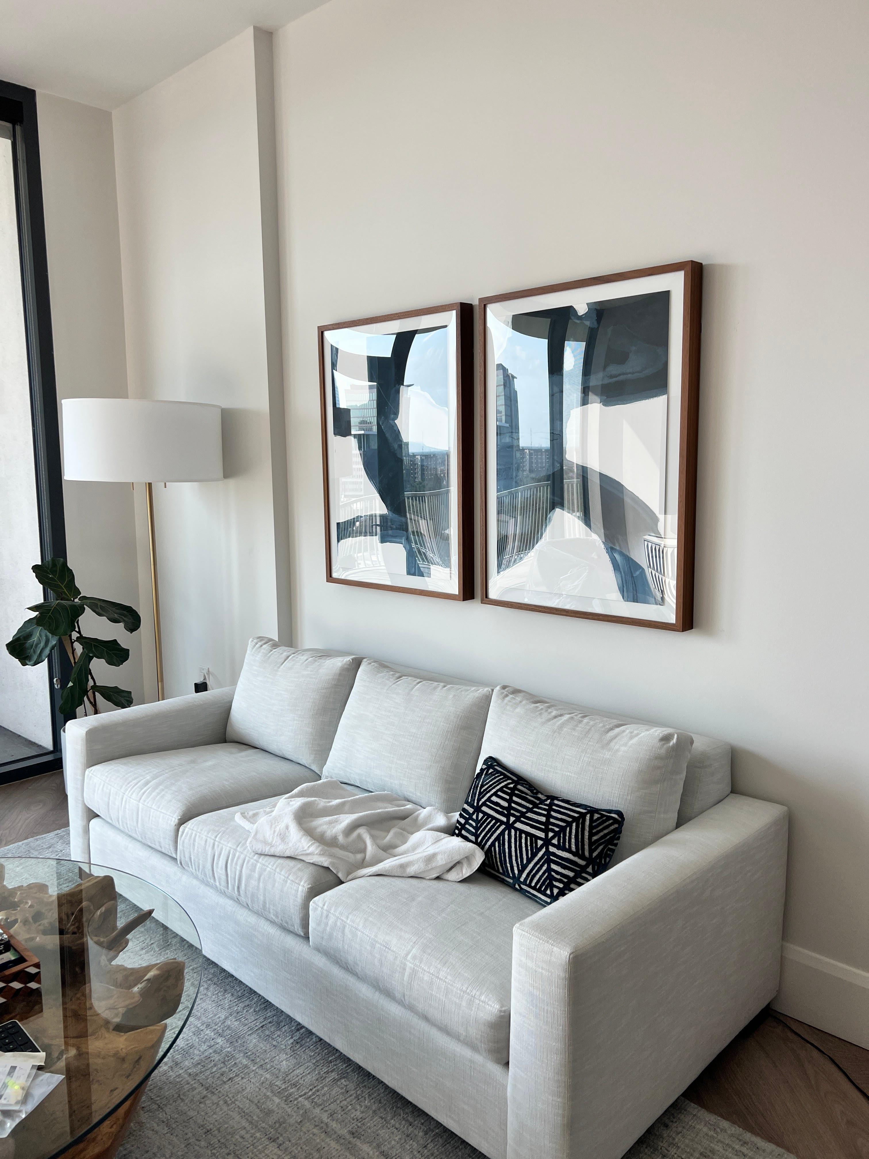 Framed wall art installed above a sofa in a residential living room.