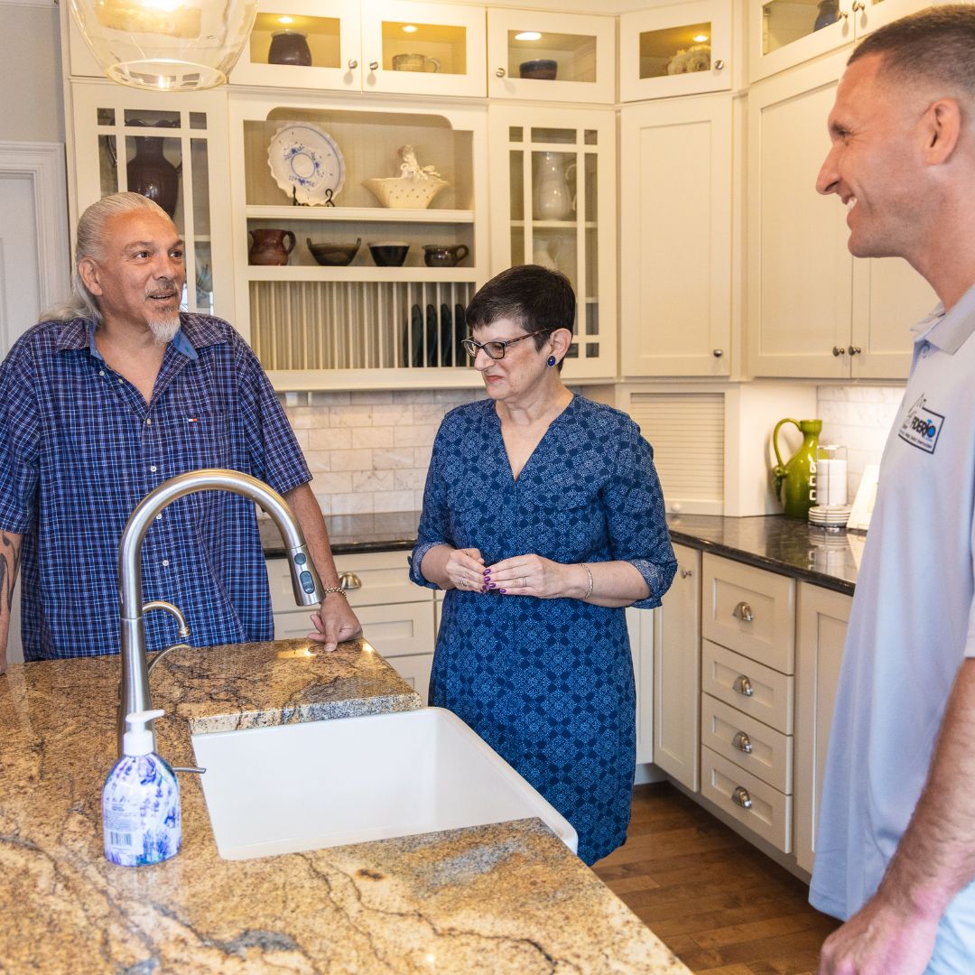 Clients tour a recently remodeled kitchen with a Fiderio representative, discussing layout and finishes.