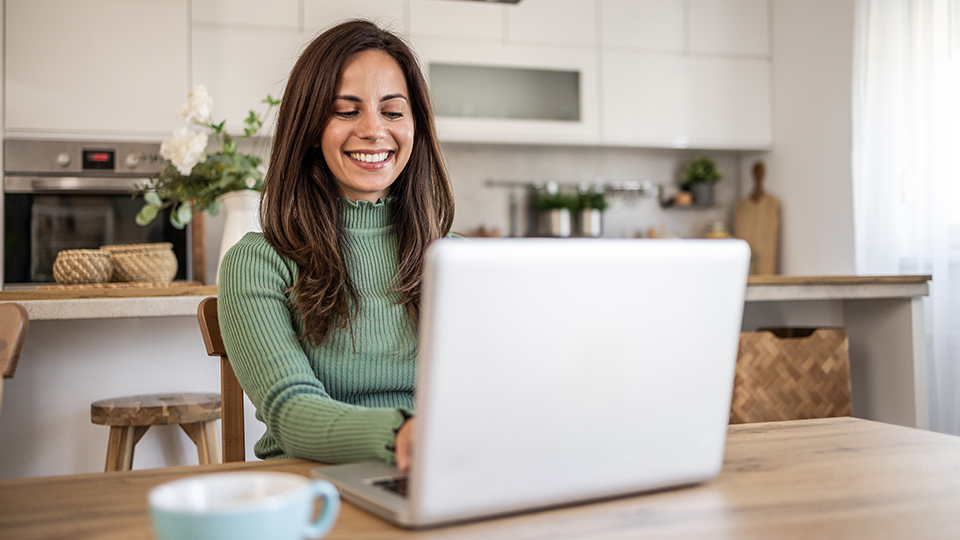 A happy woman using a laptop