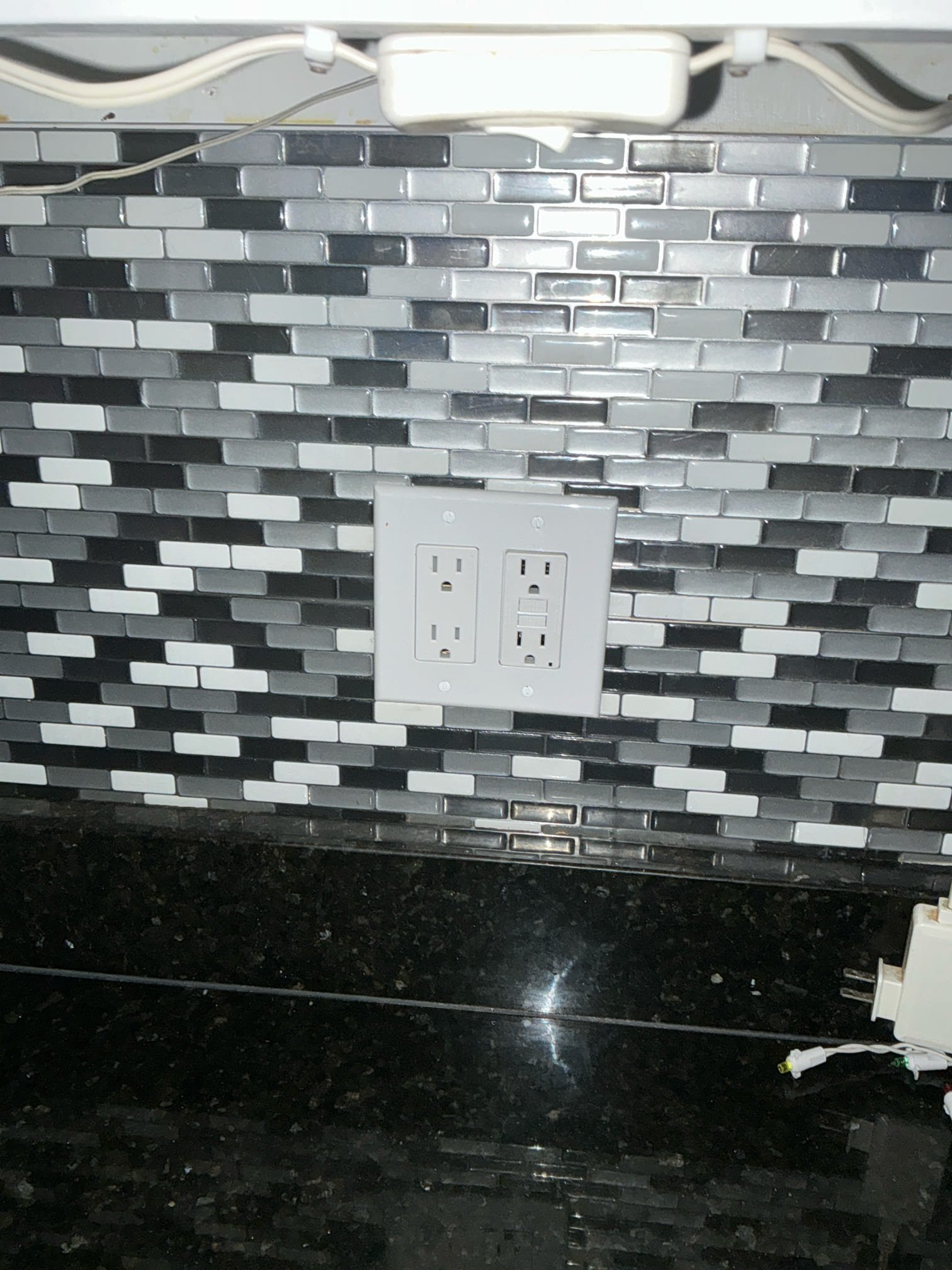 Thomas Edison Electric installed a dual GFCI outlet setup on a kitchen backsplash in a Philadelphia, PA home. The two-gang plate pairs a standard outlet with a GFCI-protected receptacle, providing code-compliant power along the granite countertop.
