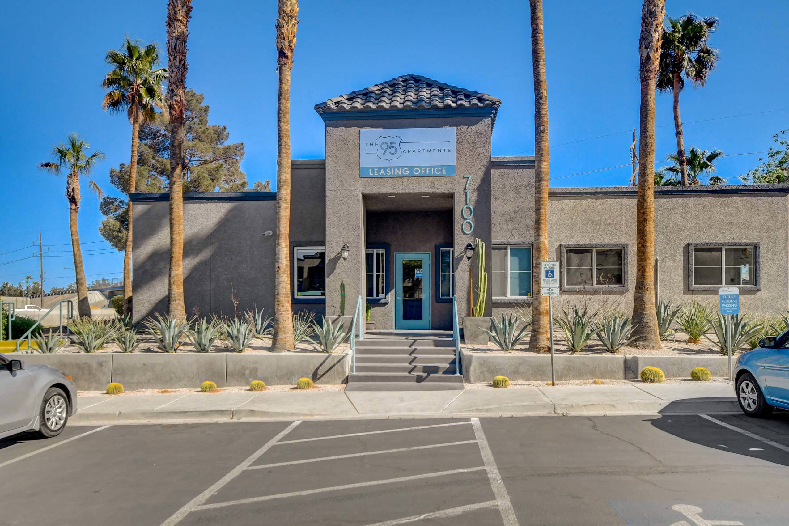 A building with a sign that says "950" and "EXAMINING OFFICE" is surrounded by palm trees