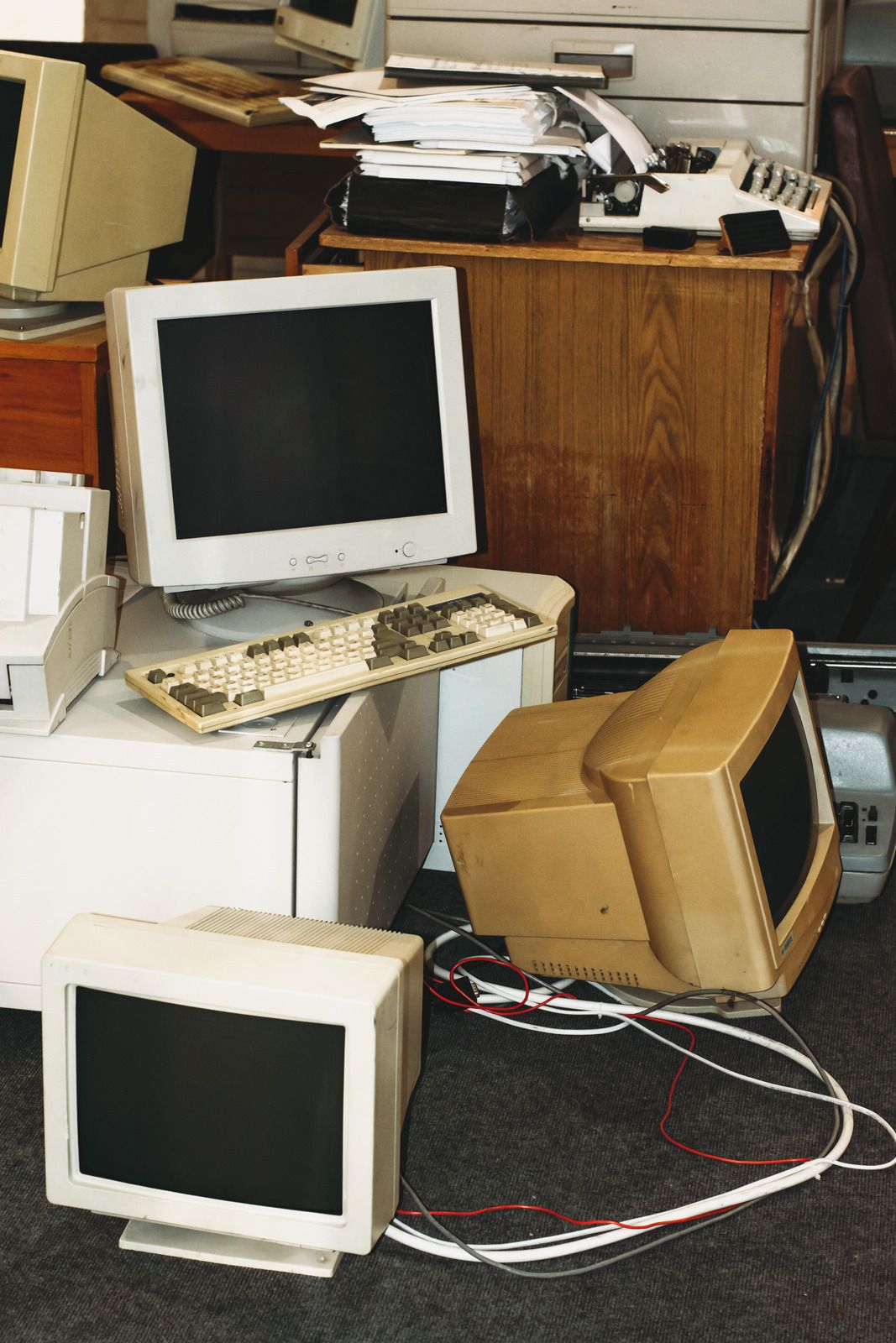 Stack of old computer monitors and office equipment, representing outdated technology disposal, recycling, and junk removal services for residential or commercial cleanouts.