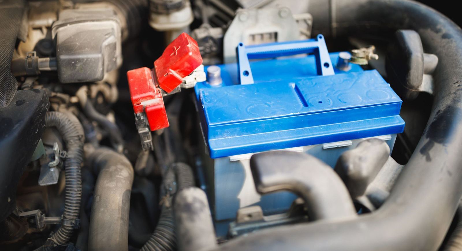 Series of automotive repair scenes showing car battery replacement, engine oil pouring, AC pressure testing, engine disassembly, and vehicle lifted in workshop. Mechanics perform diagnostics and repairs using professional tools, highlighting maintenance processes inside a modern auto repair garage environment.