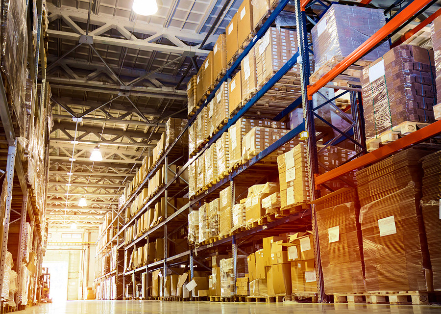 Warehouse aisle with pallet racking and stored inventory, representing RackingDeals.com warehouse storage solutions.