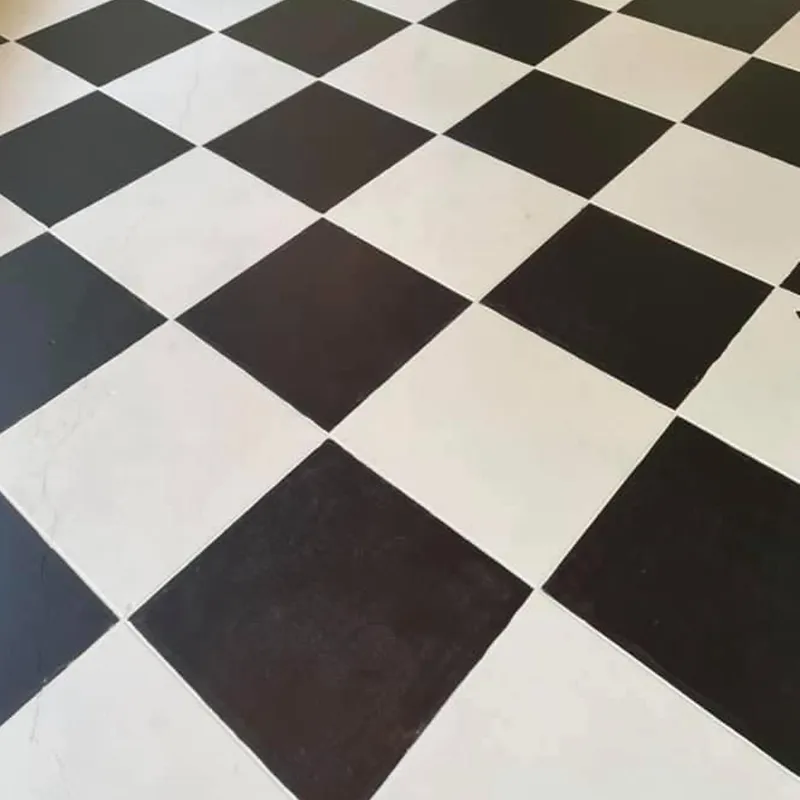 A black and white checkered floor with diamond-shaped tiles viewed from a slightly elevated angle.