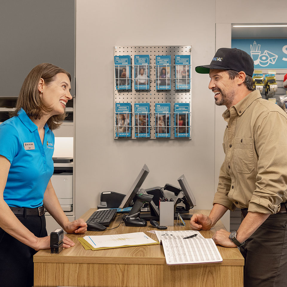 UPS Store associate assisting customer at counter